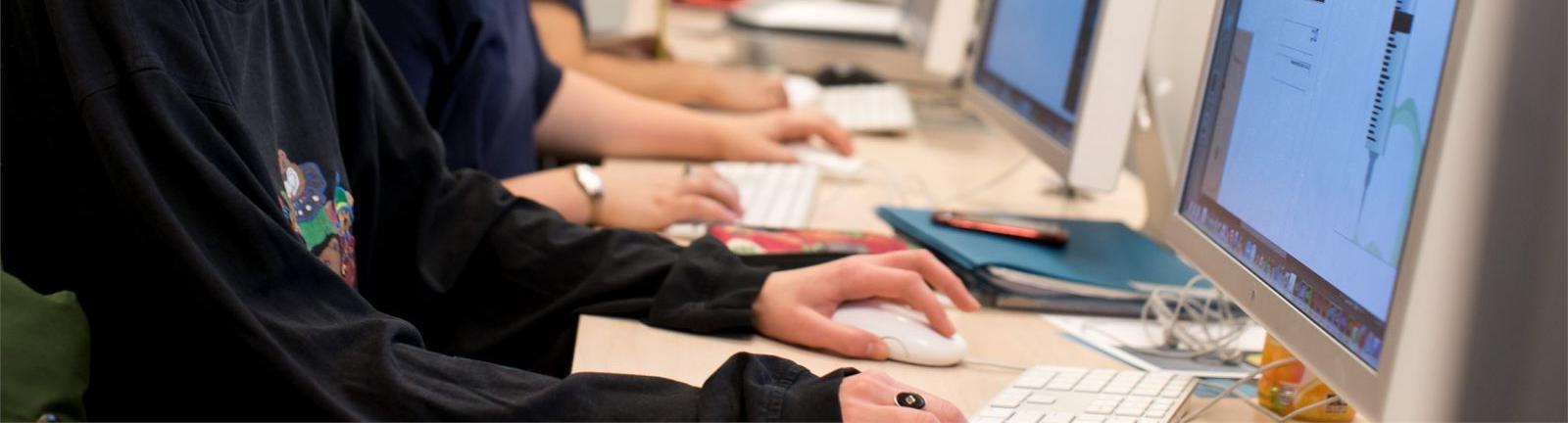 在坦普尔大学的实验室里，戴眼镜的女孩坐在电脑屏幕前，双手放在键盘上.