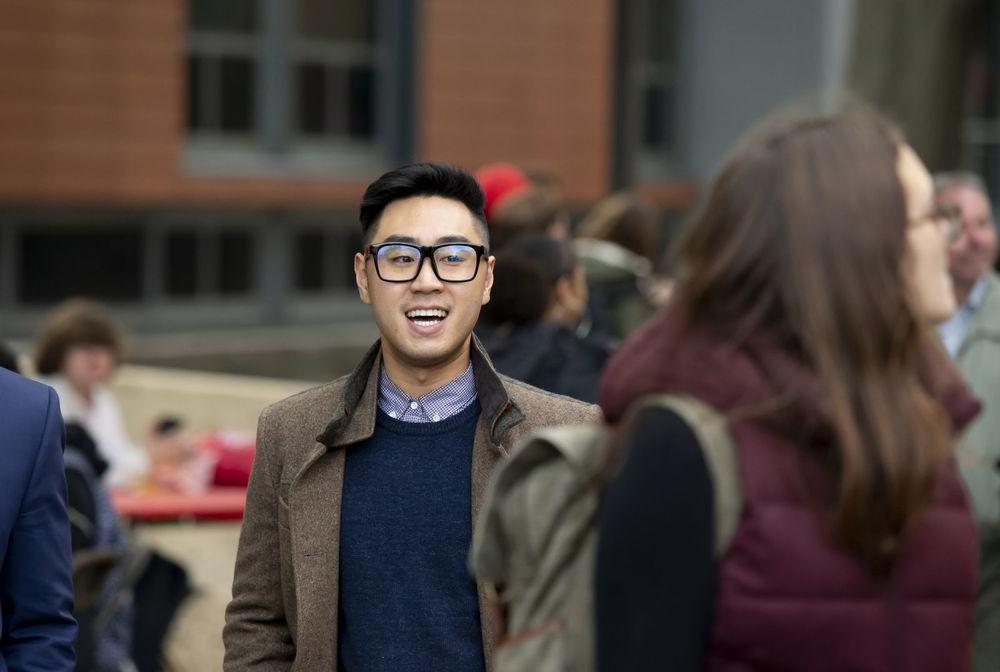 A Fox student talks with his peers outside of Alter Hall.