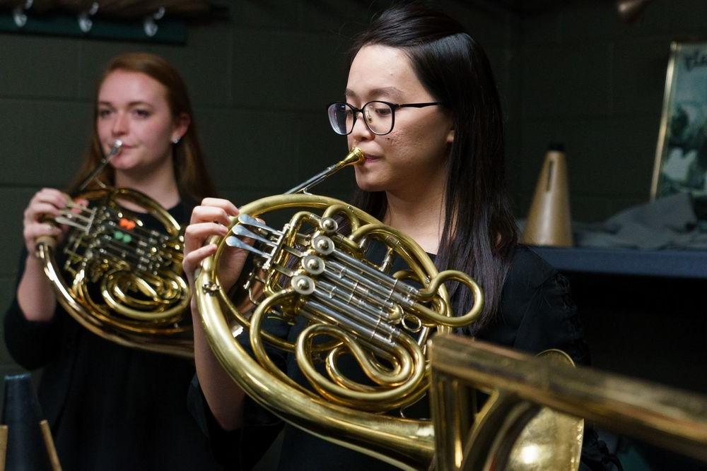 Two Temple University Boyer College of Music and Dance students play the french horn.